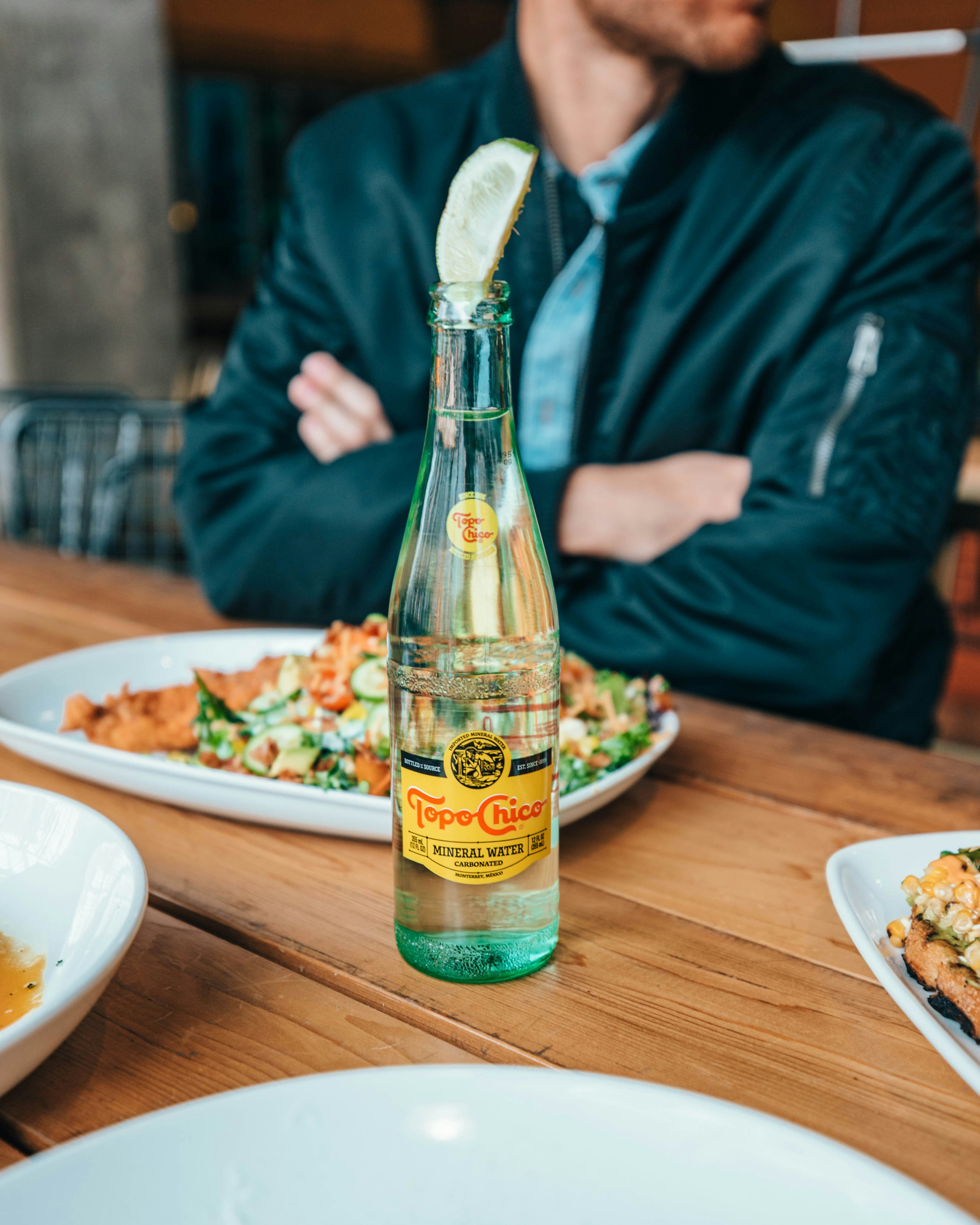 clear glass bottle on brown wooden table